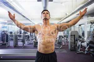 Shirtless bodybuilder standing in gym