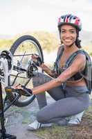 Fit woman fixing the chain on her bike