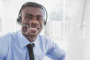 Happy businessman working at his desk wearing headset