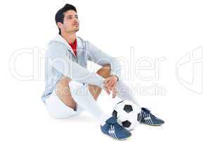 Football player sitting with ball