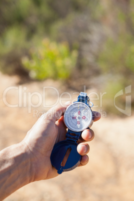 Hiker holding his compass in the countryside