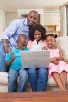 Happy family relaxing on the couch shopping online