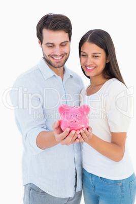 Happy couple holding their piggy bank