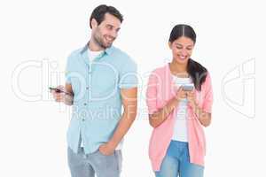 Happy couple sending text messages