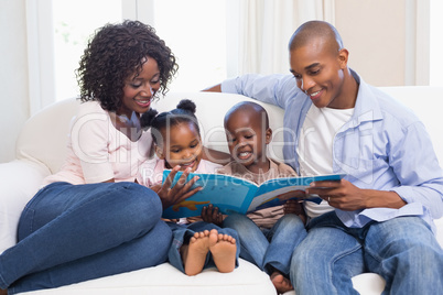 Happy family on the couch reading storybook