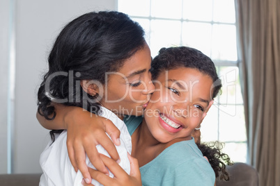 Mother and daughter hugging on the couch