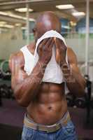 Muscular man wiping sweat after workout