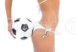 Fit girl in white bikini holding football