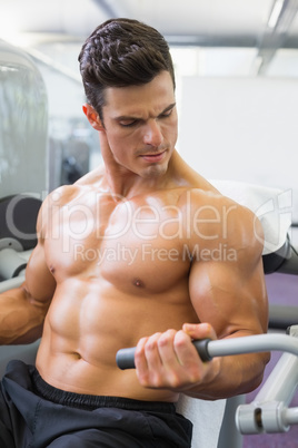 Determined muscular man working on abdominal machine