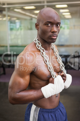 Serious shirtless muscular man in gym