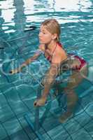 Fit blonde using underwater exercise bike