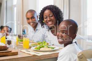 Happy family smiling at camera at lunch