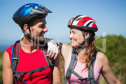 Active couple cycling in the countryside smiling at each other