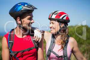 Active couple cycling in the countryside smiling at each other