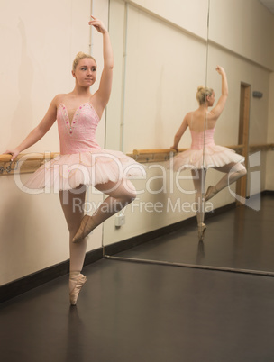 Beautiful ballerina standing en pointe with the barre