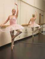 Beautiful ballerina standing en pointe with the barre