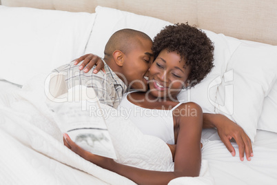 Happy couple lying in bed cuddling