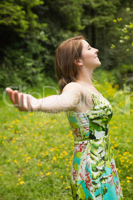 Woman with arms outstretched in field