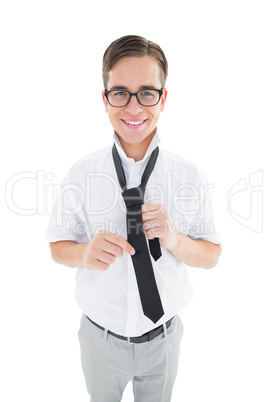 Geeky hipster fixing his tie smiling at camera