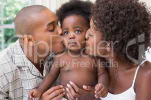 Happy couple on bed with baby daughter