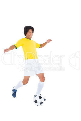 Football player in yellow kicking ball