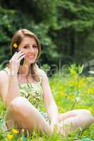 Relaxed woman using mobile phone in field