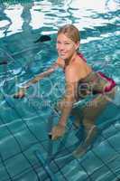 Fit happy blonde using underwater exercise bike