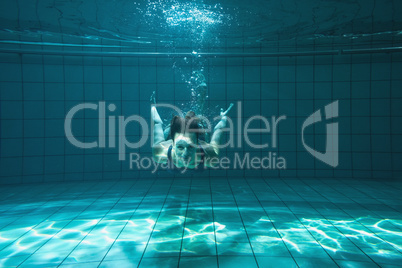 Athletic swimmer smiling at camera underwater