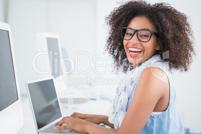 Pretty hipster working at her desk on laptop