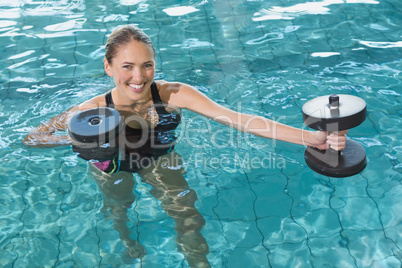 Fit blonde working out with foam dumbbells