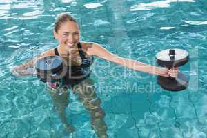 Fit blonde working out with foam dumbbells