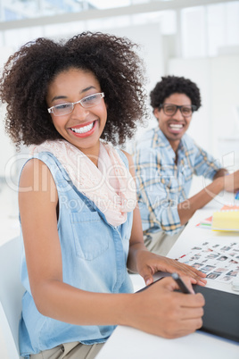 Happy design team working at desk smiling at camera