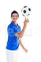 Football player in blue spinning ball