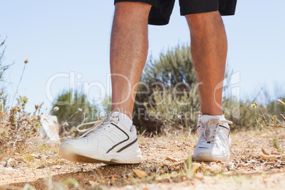 Fit man walking down mountain trail