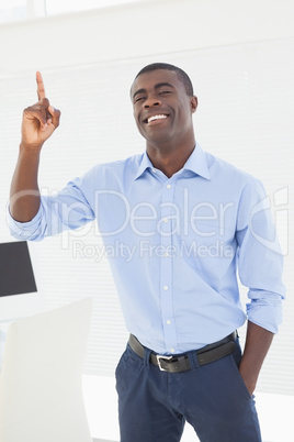 Happy businessman pointing up with finger