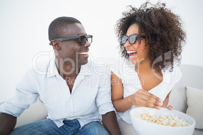 Couple sitting on couch together watching 3d movie