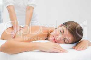 Attractive young woman receiving back massage at spa center