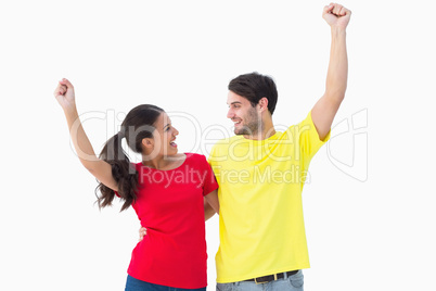Excited couple cheering in red and yellow tshirts