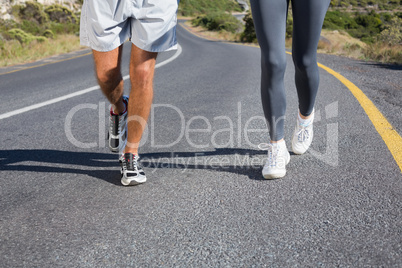 Fit couple running together up a road