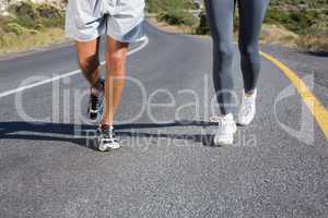 Fit couple running together up a road