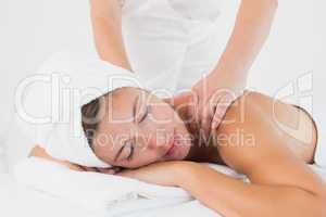 Attractive woman receiving shoulder massage at spa center