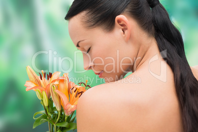 Beautiful nude brunette smelling bunch of lilies