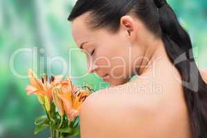 Beautiful nude brunette smelling bunch of lilies