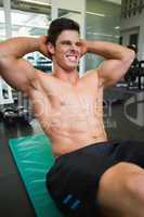 Determined muscular man doing abdominal crunches