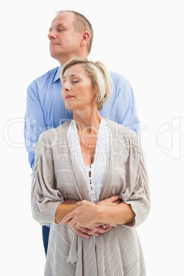 Happy mature couple embracing with eyes closed
