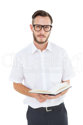 Geeky young man reading from black book