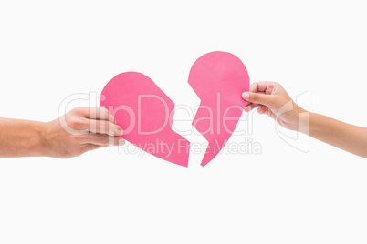 Hands holding two halves of broken heart