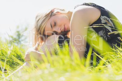 Pretty blonde in sundress sitting on grass