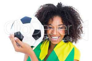 Pretty football fan with brazilian flag smiling at camera