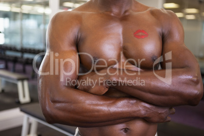 Shirtless muscular man with lipstick mark on chest